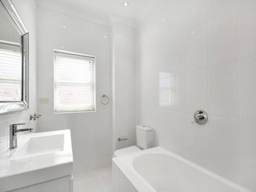 悉尼Stylish & Sunlit Bellevue Hill的白色的浴室设有水槽和浴缸。