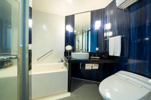 熊本KOKO HOTEL Premier Kumamoto的浴室配有卫生间、盥洗盆和淋浴。