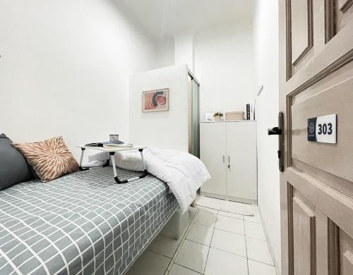 雅加达Kos Awany CoLiving的一间小卧室,配有一张床和一张桌子