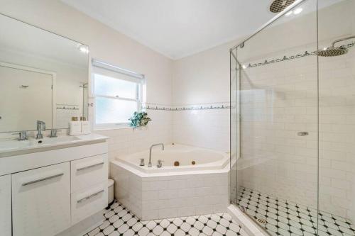 BowdenPetal and Bloom - 3BR Family CBD的白色的浴室设有浴缸和淋浴。