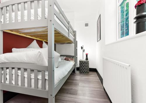 伦敦Radiant Serenity: 2BR Flat Sleeps 5 -Warm Ambiance的一间带两张双层床的卧室和楼梯