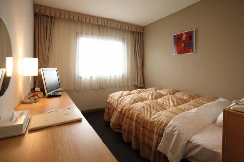 丸龟市丸龟大仓饭店的酒店客房配有一张床和一张带电脑的书桌
