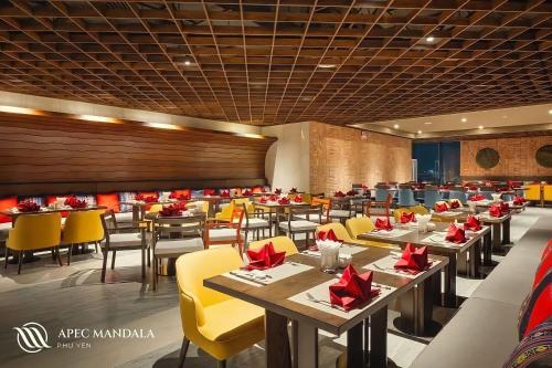 绥和市Mia Apec Mandala Phú Yên的用餐室配有桌子和黄色椅子
