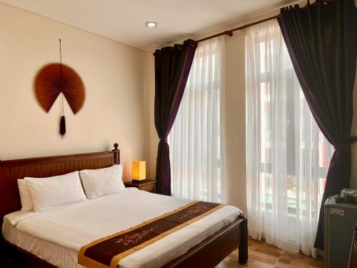 芹苴南波精品酒店的一间卧室设有一张床和一个大窗户