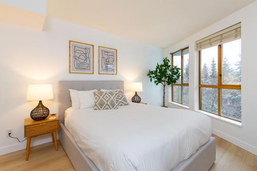 惠斯勒600 SQFT 1 Bed 1 Bath Mountain View Suite at Cascade Lodge in Whistler Village Sleeps 4的一间白色卧室,配有一张床和两盏灯