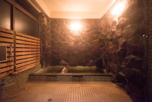雾岛市おもや彩OmoyaSai-天然温泉付き貸別荘1棟貸し的带淋浴的浴室(带石墙)