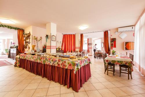 阿巴迪亚圣萨尔瓦托雷法布里尼酒店的大房间,设有两张桌子,上面有食物