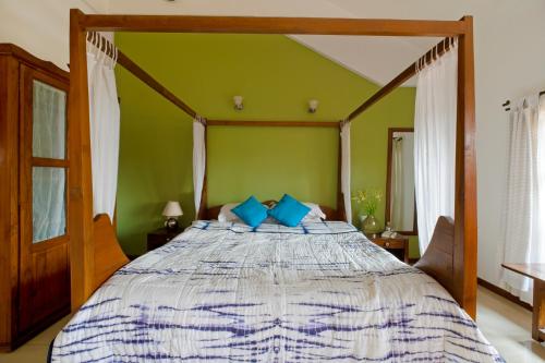 科尔瓦Skylark Resort的一间卧室配有一张带蓝色枕头的大床
