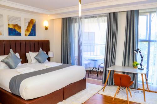 内罗毕Sangara by Edmor Suites的酒店客房配有一张床铺、一张桌子和一张书桌。