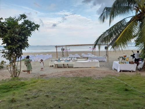 San AgustinCRUISER'S BEACH RESORT的海滩上的婚礼招待会,配有白色的桌子