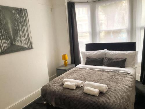 KentGravesend 2 Bedroom Spacious Stylish Apartment - Sleeps upto 6 - 2 Min Walk to Station的一间卧室配有一张床,上面有两条毛巾
