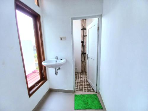 斯勒曼Homestay Jogja Prambanan By Simply Homy的白色的浴室设有水槽和窗户。