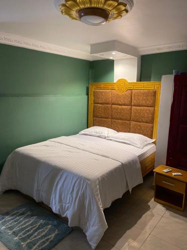 林贝Primier Mansion Guest Home的一间卧室设有一张大床和绿色的墙壁