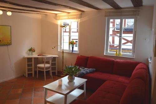 布里德尔Ferienhaus Old Winery的客厅配有红色的沙发和桌子