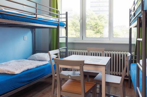 布拉迪斯拉发Patio Hostel Dorms的客房设有桌子、床和双层床。