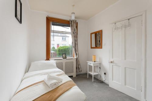 爱丁堡Stunning 2 bed apartment Free Parking的一间卧室设有两张床和窗户。