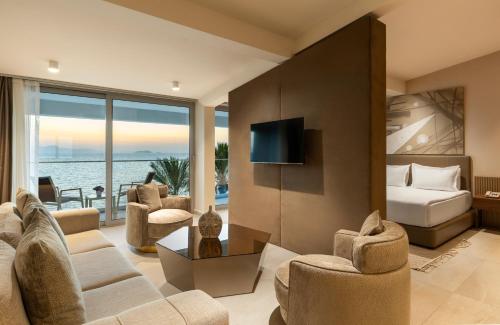 图尔古特雷斯Arin Resort Bodrum的客厅配有沙发、椅子和电视