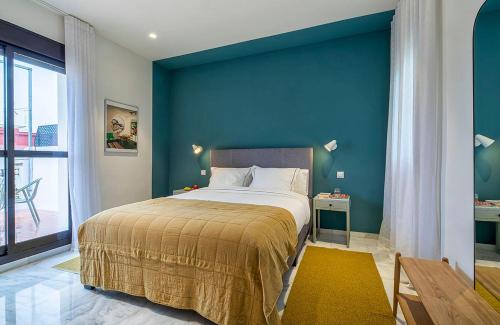 塞维利亚Carmen de Triana的一间卧室设有一张蓝色墙壁的大床