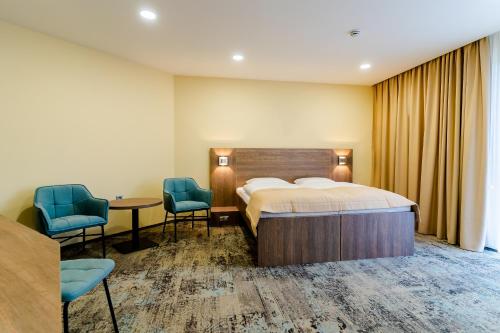利托斯基简Spa & Wellness Hotel Fitak****的一间卧室配有一张床、两把椅子和一张桌子