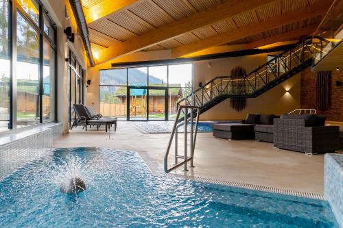 利托斯基简Spa & Wellness Hotel Fitak****的一座房子内带螺旋楼梯的游泳池