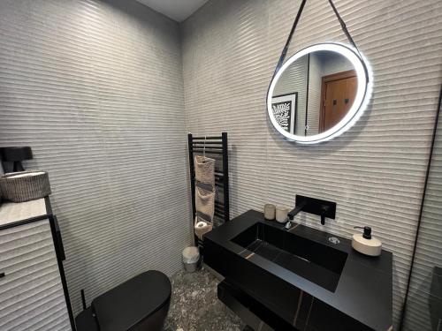 拉兹洛格Katarino Spa Chalet的浴室设有黑色水槽和镜子
