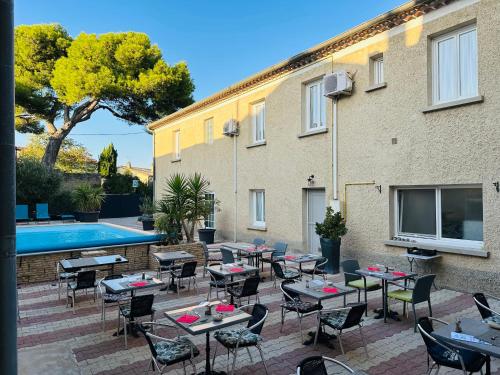 索尔古河畔的恩特莱奎斯Logis Hôtel La Bastide d'Entraigues的一个带桌椅的庭院和一个游泳池