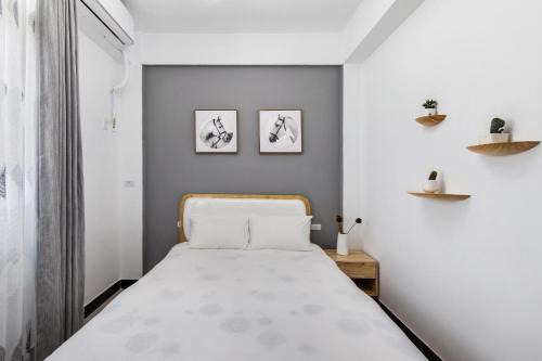 金宁乡棲遲民宿的卧室配有一张床,墙上挂有两张照片
