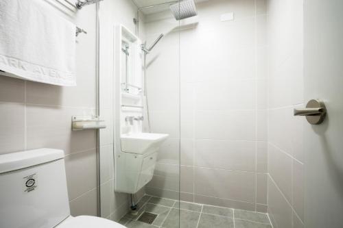首尔Parkavenue Guesthouse的白色的浴室设有卫生间和淋浴。