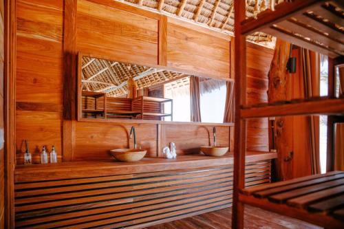 布韦朱TIKI Beach Club & Resort的木制客房内的带两个盥洗盆的浴室