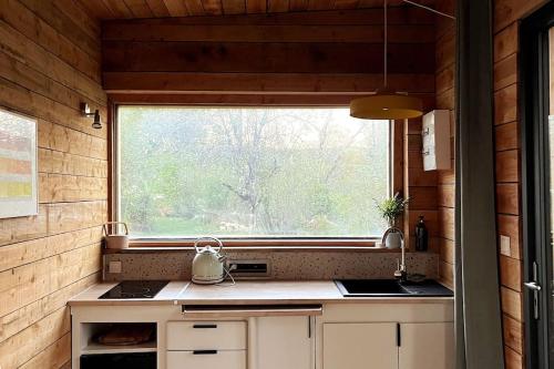 Lissac et MouretLes cabanes de Julie的一个小房子里带窗户的厨房