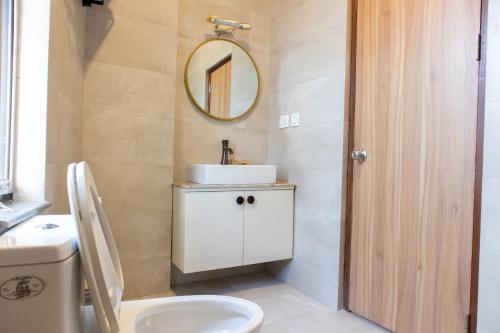 加德满都Kibu Apartments的一间带卫生间、水槽和镜子的浴室
