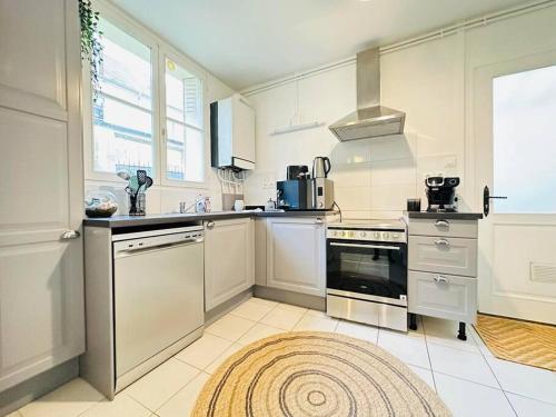 拉昂Maison des chenizelles的厨房配有白色家电和地板上的地毯
