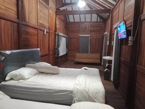 岩望NK Villa Syariah And Cafe Prigen的一间卧室配有一张床和一台电视。