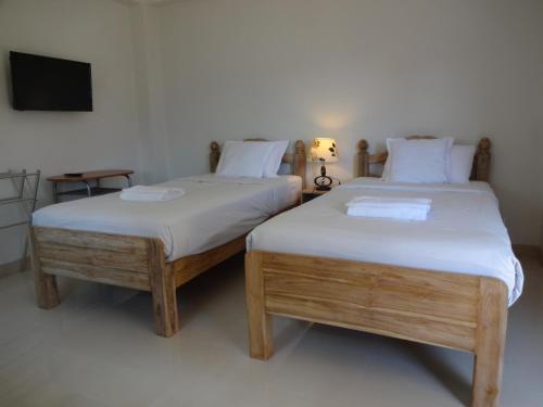 清迈Rena House Chiang Mai的两张睡床彼此相邻,位于一个房间里