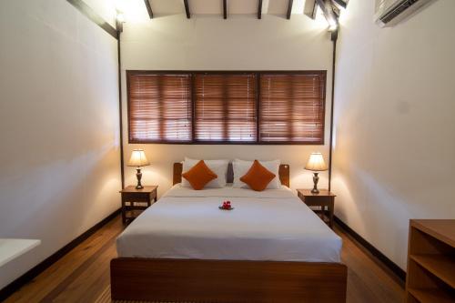 秾莎Nongsa Village的一间卧室配有一张带两盏灯的床和一扇窗户。