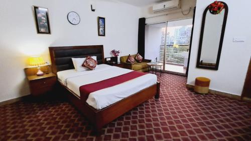 达卡Garden Residents Uttara - Lake View的一间卧室配有一张床和一个沙发
