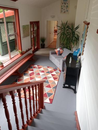 OtiraRata Lodge Accommodation的一间带楼梯和沙发的客厅