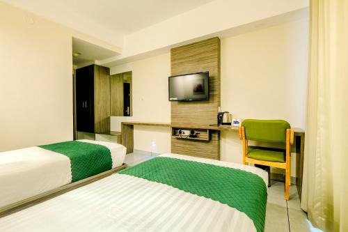 特里凡得琅The HEARTLAND Hotel的酒店客房设有两张床和电视。