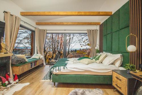 SohodolDoza de Verde Chalet Bran的绿色卧室设有一张大床和一个窗户