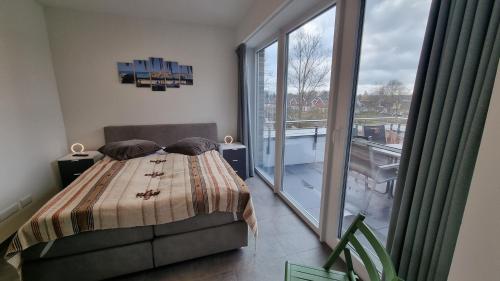 文迪施里茨Park-Apartment Scharmützelsee Wohnung 13的一间卧室设有一张床和一个大窗户