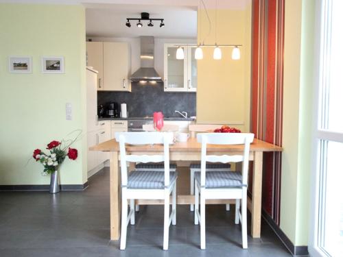奥斯特巴德里克Villa Antonia Whg_ 03的厨房配有木桌和白色椅子