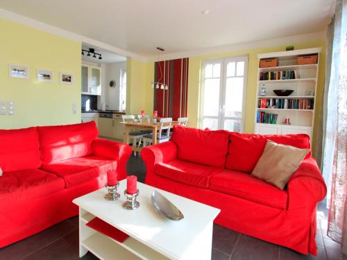 奥斯特巴德里克Villa Antonia Whg_ 03的客厅配有红色沙发和白色桌子