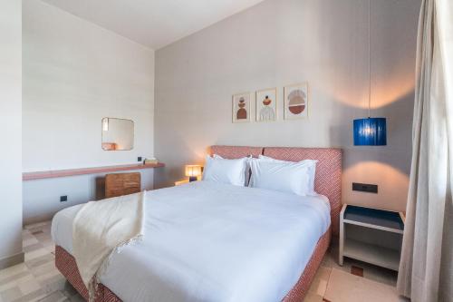马拉喀什JEMAA EL FNA Suites & Spa的卧室配有一张白色大床