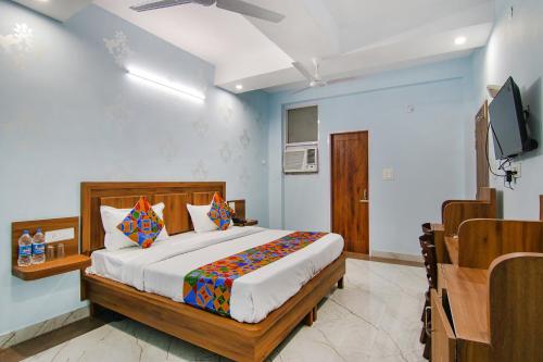钱德加尔FabHotel Hari Residency的一间卧室配有一张床和一台平面电视