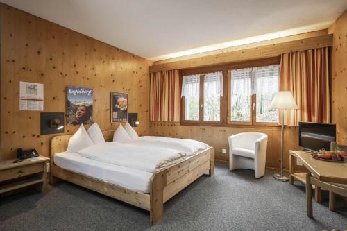 英格堡Hotel Bänklialp的一间卧室配有一张床、一张书桌和一台电视