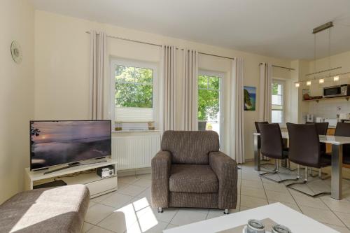 奥斯特巴德里克Villa Elsa _Wohnung 5_的客厅配有电视和桌椅