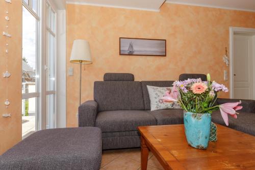 奥斯特巴德里克Villa Rosita Whg_ 7 _LISA_的客厅配有沙发和鲜花桌