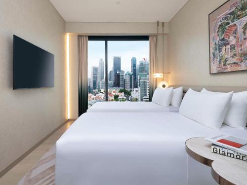 新加坡Mondrian Singapore Duxton的酒店客房设有两张床和大窗户。