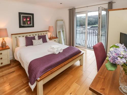 米尔福德港Curlew的一间卧室设有一张床和一个阳台