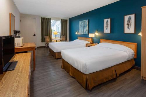 阿默斯特Travelodge by Wyndham Amherst的酒店客房设有两张床和一台平面电视。